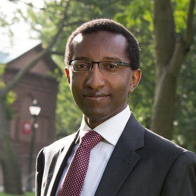 black man with glasses in a suit