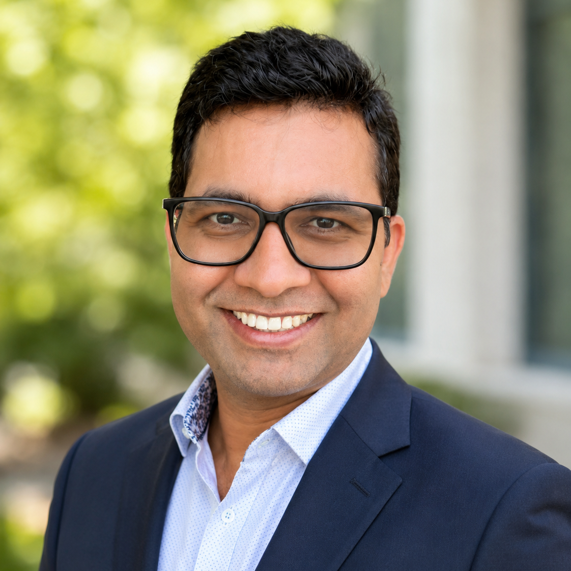 man with black hair and glasses
